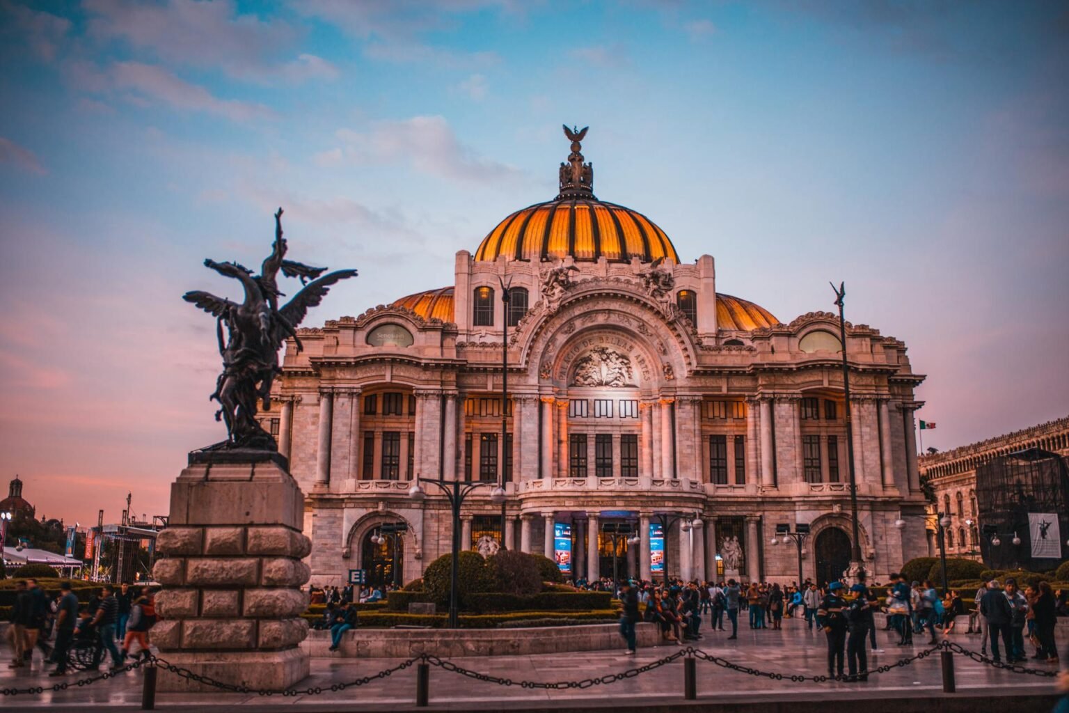 Palacio de Bellas Artes al atardecer, con luces cálidas iluminando su fachada.