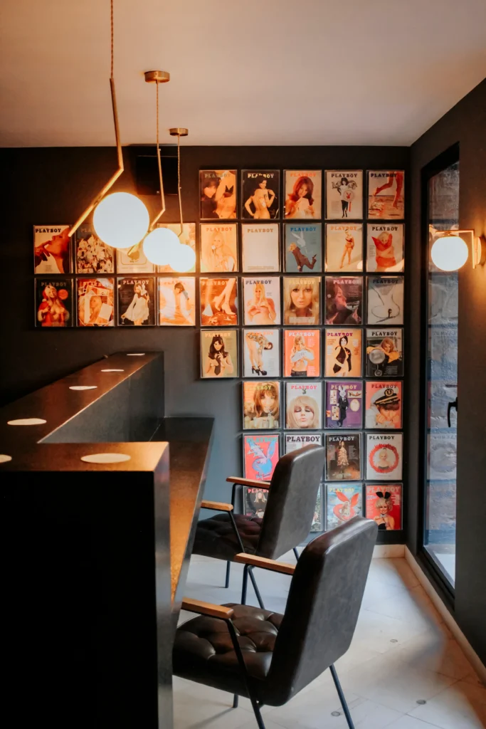 Espacio agradable con una zona para sentarse, ideal para estudiar o trabajar, y una pared adornada con portadas de revistas.